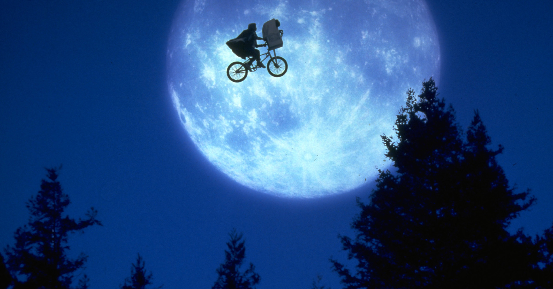 E.T. the Extra Terrestrial -elokuvan mainoskuva, jossa poika pyöräilee yötaivaalla.
