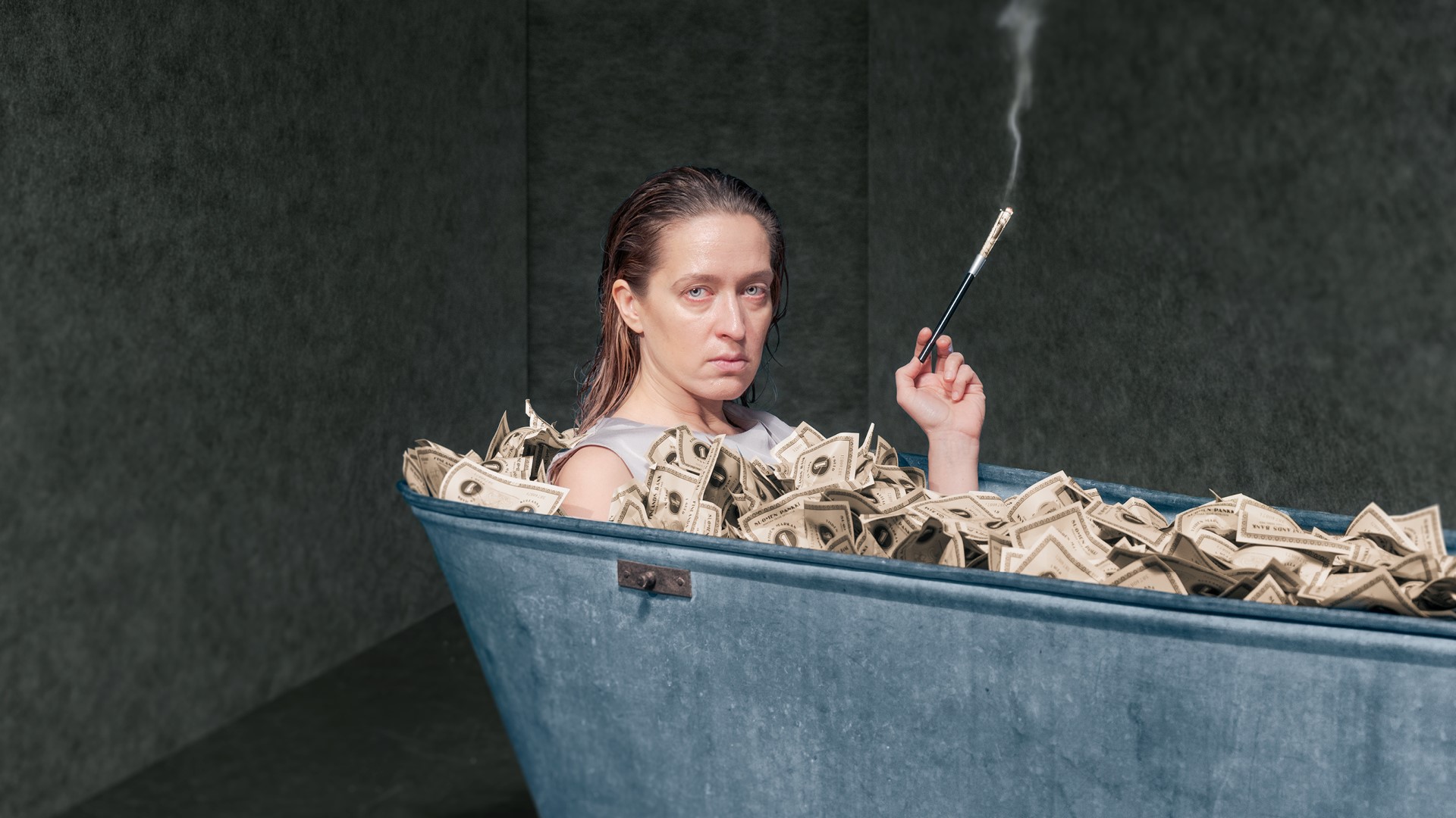 Elsa Saisio rahantäyteisessä kylpyammeessa