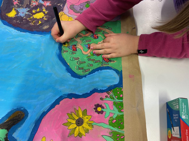 Ett barn som ritar ett färgglatt konstverk.