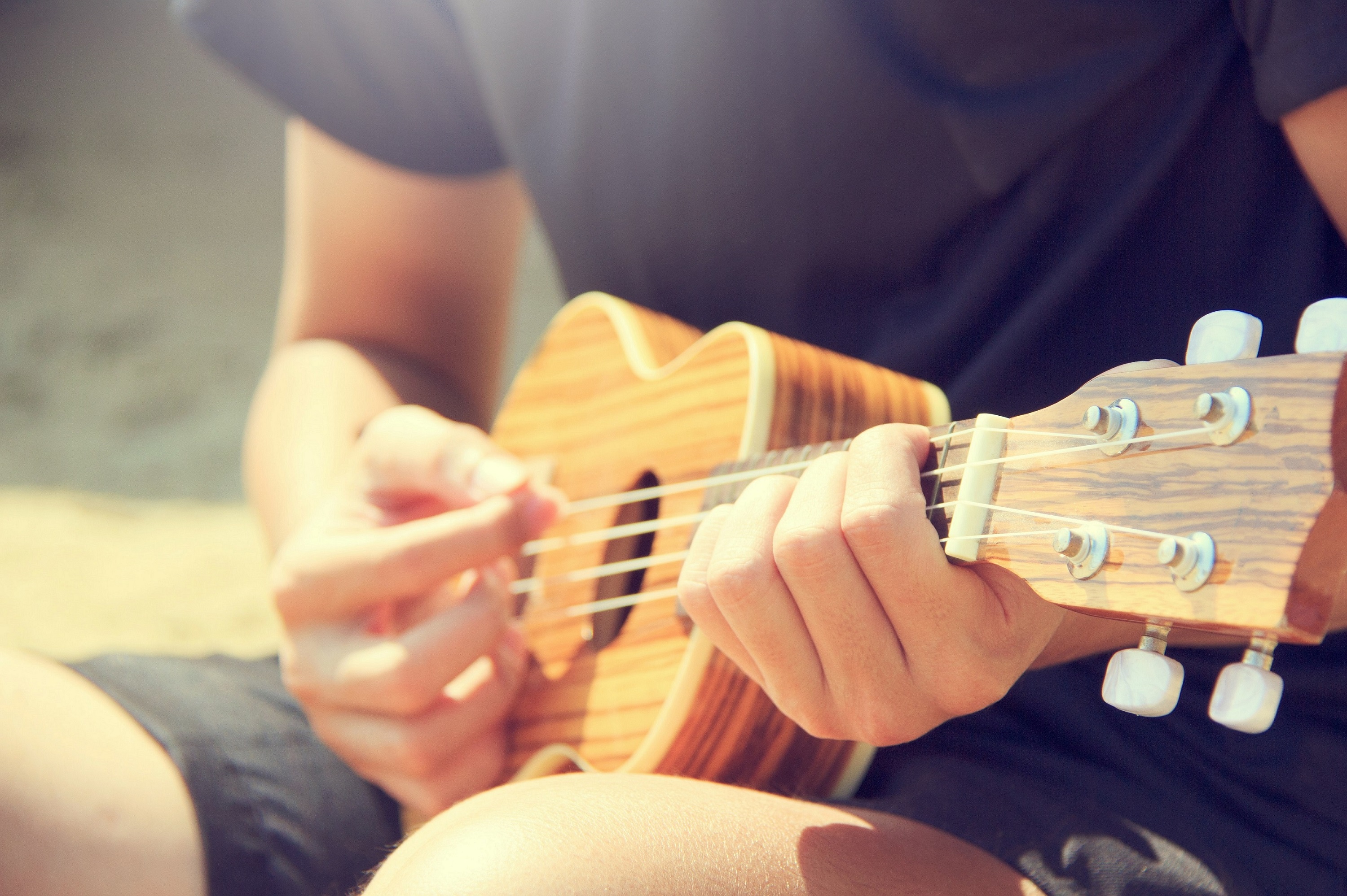 ihminen soittaa ukulelea